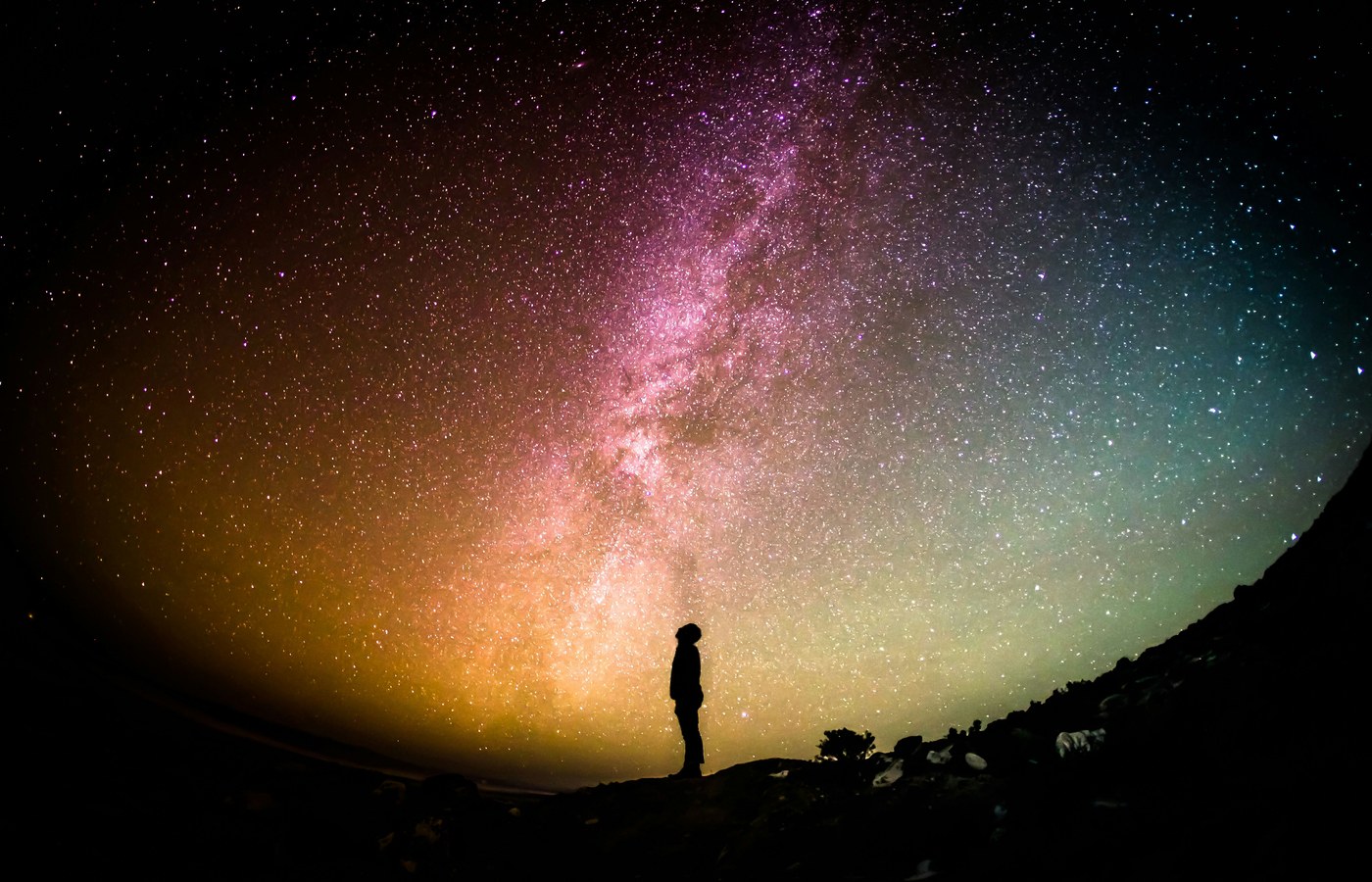 Person standing under the Milky Way, representing the night-sky community MySkyDome is built for
